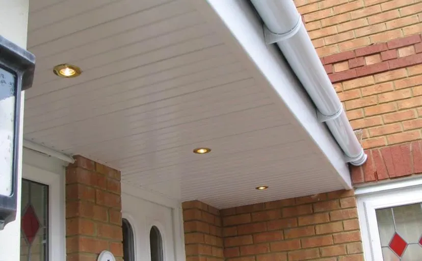 Close-up of new white UPVC soffits with spotlights and matching guttering