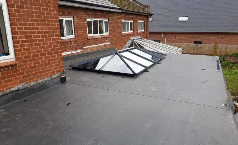 A modern flat roof extension with a prominent glass roof lantern, showcasing expert flat roofing installation and natural light integration.